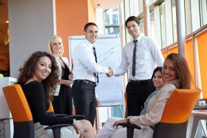 46193379 - businessman shaking hands to seal a deal with his partner and colleagues in a modern office